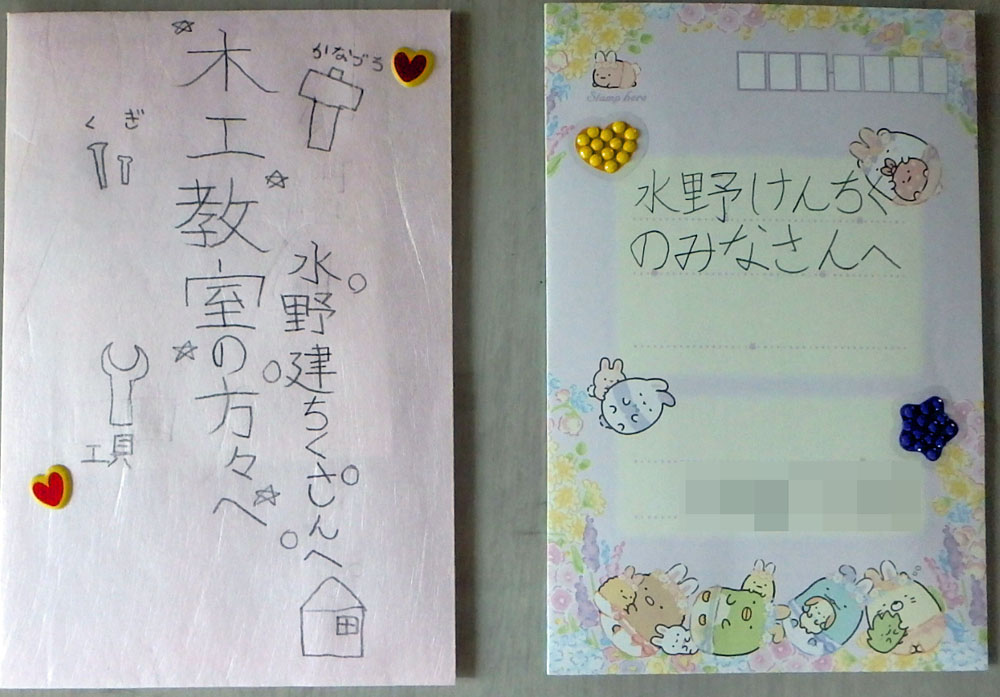 Handwritten Japanese note on pink paper with doodles of a hammer, wrench, house, stars, and hearts.